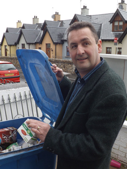 Councillor Willie Clarke pops a tetra pack into the blue bin.