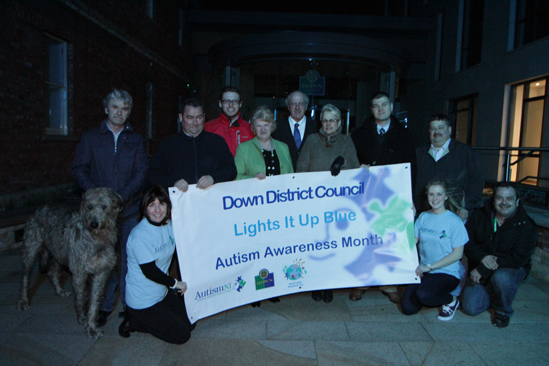 The Down Civic Forum is lit up blue in support of Autism NI - Included are, from left, Down District Councillors Eamonn mac Con Midhe, Terry Andrews, Gareth Sharvin, with Strangford MP Jim Shannon and South Down MP Margaret Ritchie, and Councillors Colin McGrath, Billy Walker and Liam Johnston. Pictured front row are Audrey Mullan and Rachel Gribben of Autism NI.