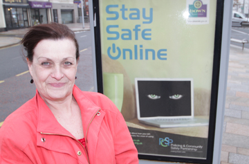 PCSP Chairperson Councillor Carmel O'Boyle pictured beside one of the big posters in Newcastle.