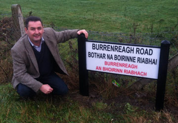  Cllr Clarke pictured at the new bilingual street sign which has been installed in Burrenreagh.