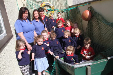 Tiny Toons assistants Karen Fitzsimons and Jennifer Davey with Leader Muala Mulholland, and some of the children al aboard a boat in their outdoor palyground.