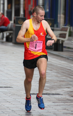 Brendan Teer checking his time in City Centre on his way to 4th place overall and the Silver medal in the NI Half Marathon Championships.