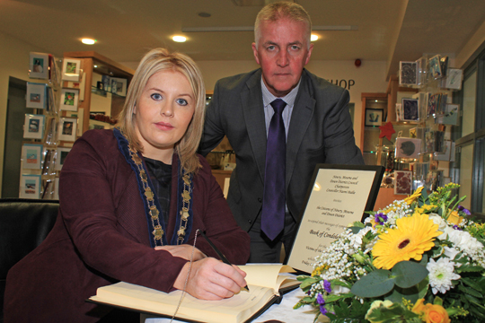 The Chairperson of Newry Mourne and Down District Council, Councillor Naomi Bailie, signs the book of condolances for the Paris massacre in the Down Arts Centre in Downpatrick accompanied by Assistant Chief Executive, Eddie Curtis.