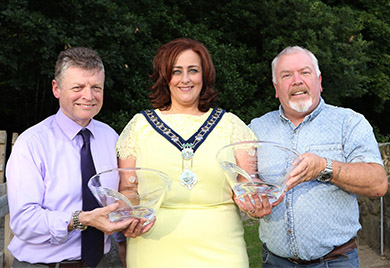 Chairperson of Newry, Mourne and Down Council Councillor Gillian Fitzpatrick presents Eamonn O'Connor and Micky McKevitt with inscribed crystal bowls to mark their fantastic fund raising efforts for the restoration work of Kilbroney Parish Church.