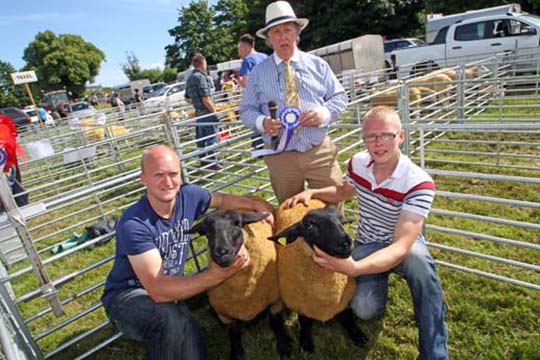 Judge Vaughan Byrne of the TFLF with Mark and John Herron from Ballyward with their winning pair of Suffolk ewe lambs.