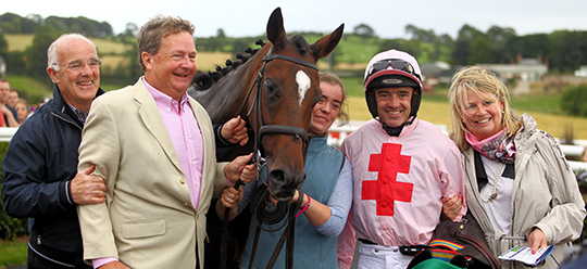 Ted Walsh with son/champion jockey, Ruby Walsh in the winners' enclosure after Sam King’s victory.