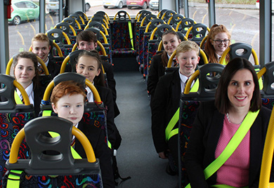 The EA reminds parents and pupils of Road Safety NI’s message ‘Be Bright, Be Seen’ by drivers when travelling to and from schools and colleges during the winter months. Pictured EA Director of Operations and Estates Sara Long with pupils from Lagan College, Belfast, buckle-up with hi-visibility seatbelts which enhance driver visibility and are easy to spot from a distance.